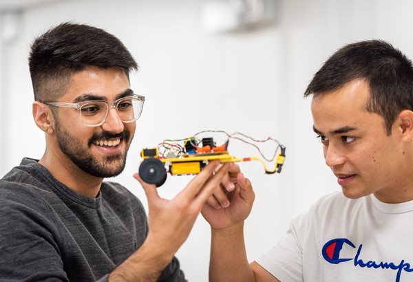 Sina Alishahpour and Isaac Flower look at electronic car